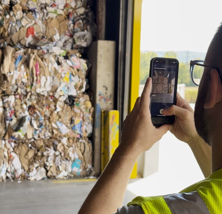 Goods receipt employee photographing a recovered paper delivery with UpCircle™ Go! on a smartphone